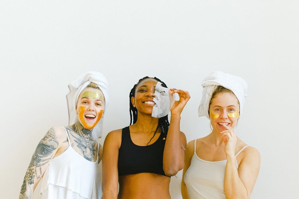 three happy women with masks and eye patches on their faces