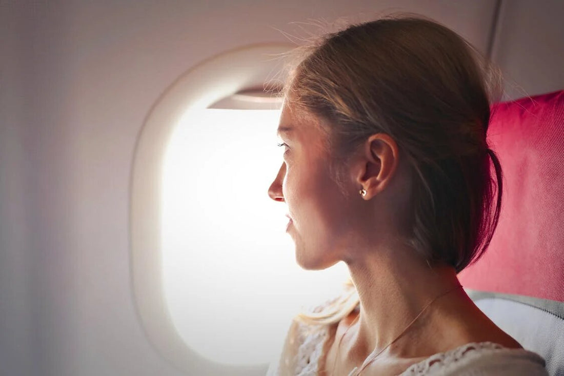 A woman with healthy skin looking out the airplane window