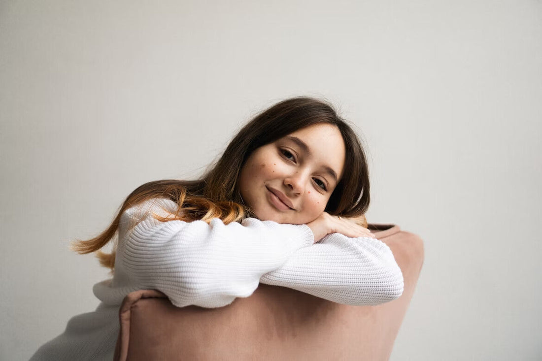 A woman with clear skin sitting on a chair