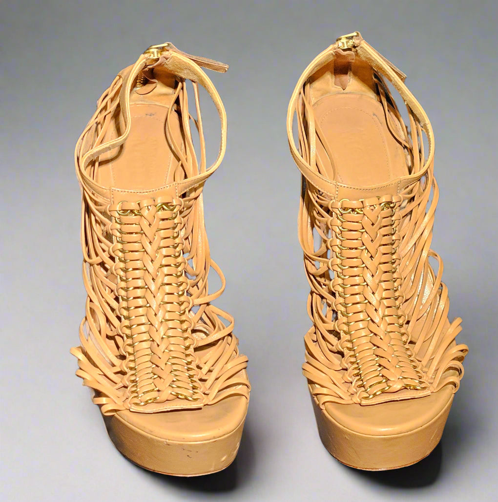 Pair of tan woven high-heeled sandals on a gray background