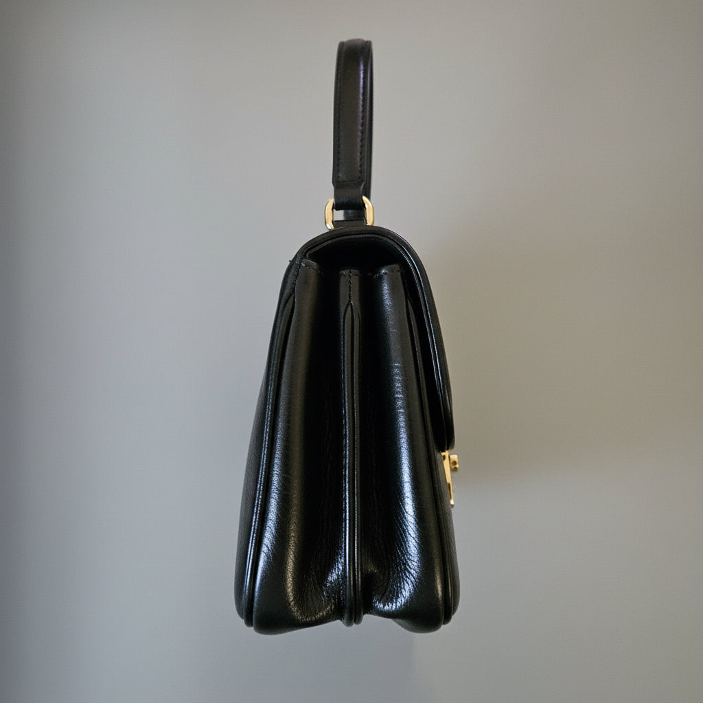 Black leather wallet on a light gray surface with a blurred background