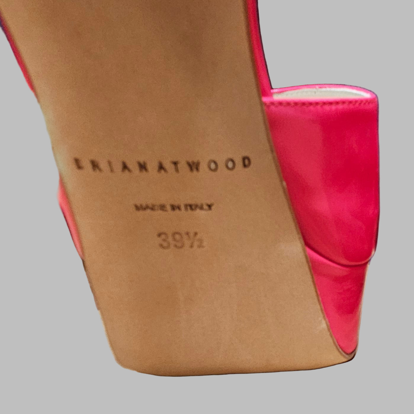 Close-up of a shoe with 'Brian Atwood' branding on a gray background