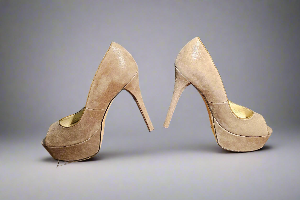Pair of beige high-heeled shoes on a clear stand against a dark background