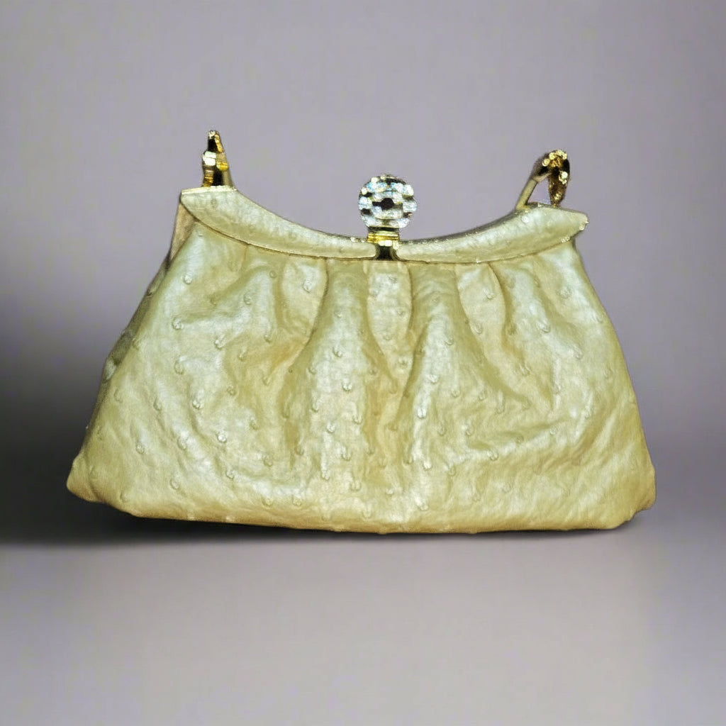 Vintage-style handbag with textured surface and gold accents on a gray background