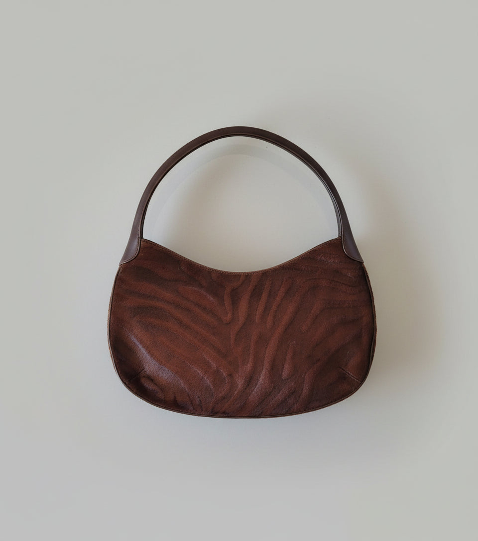 Brown textured handbag on a white surface