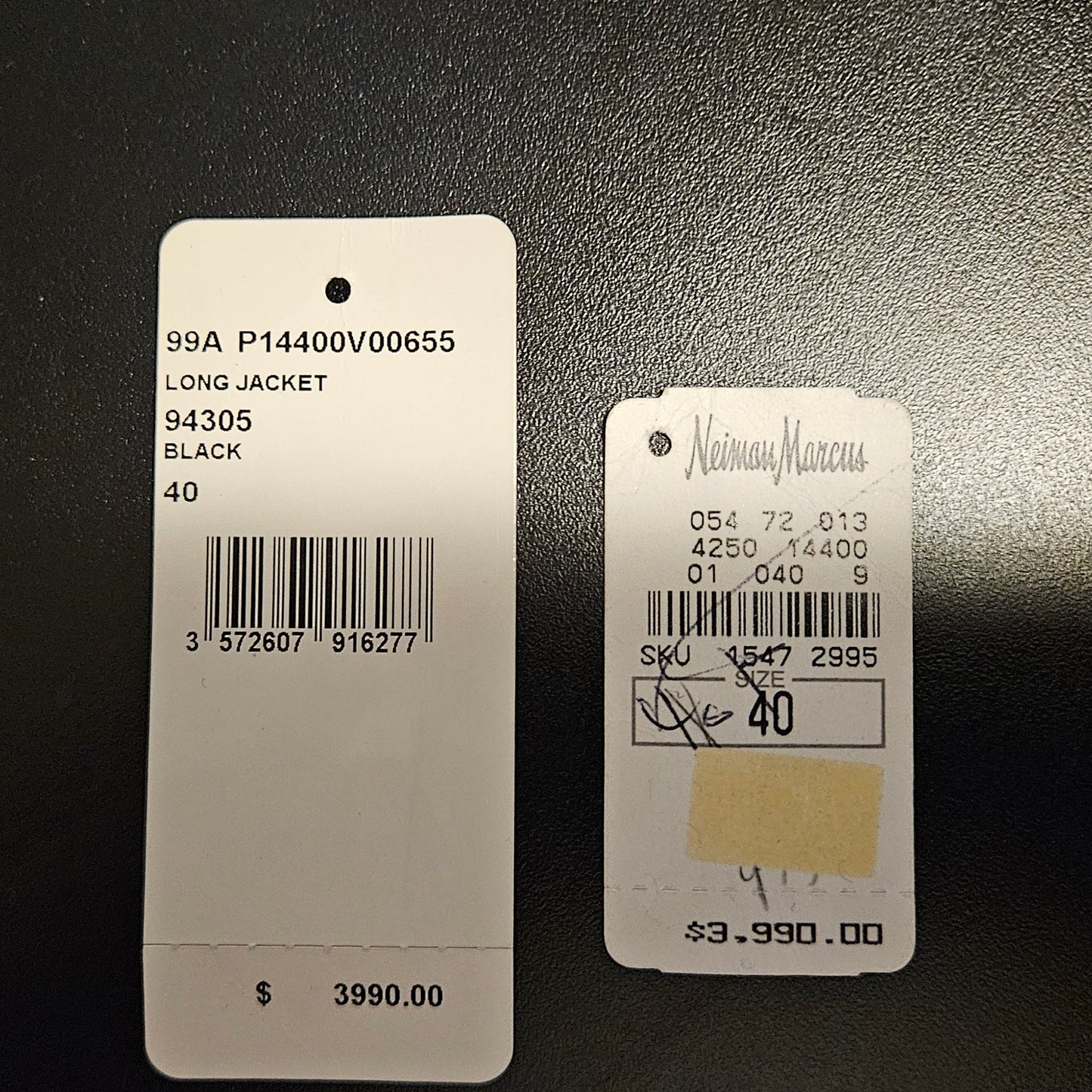 Two clothing tags with product information on a dark background