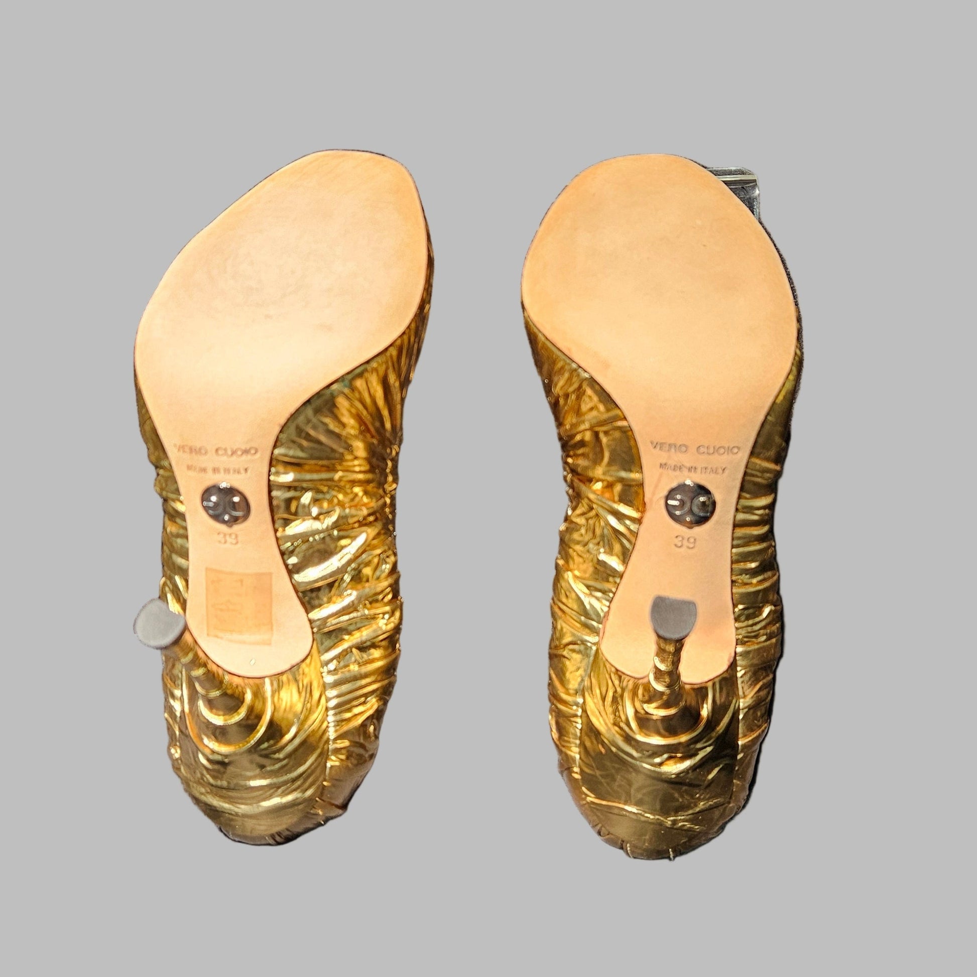 Gold insole on a black surface with a clear plastic cover
