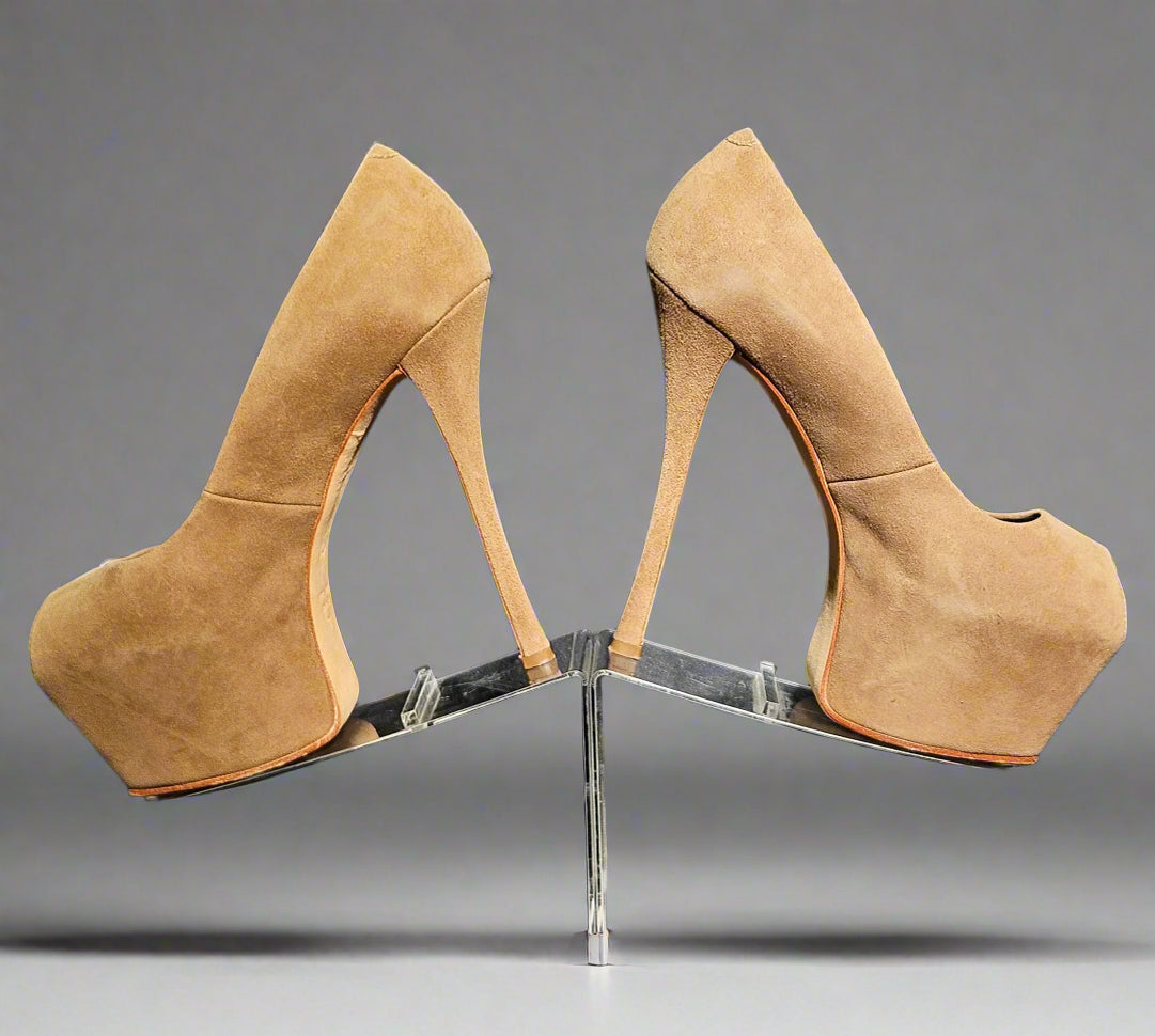 Tan suede high-heeled platform shoes on a gray background