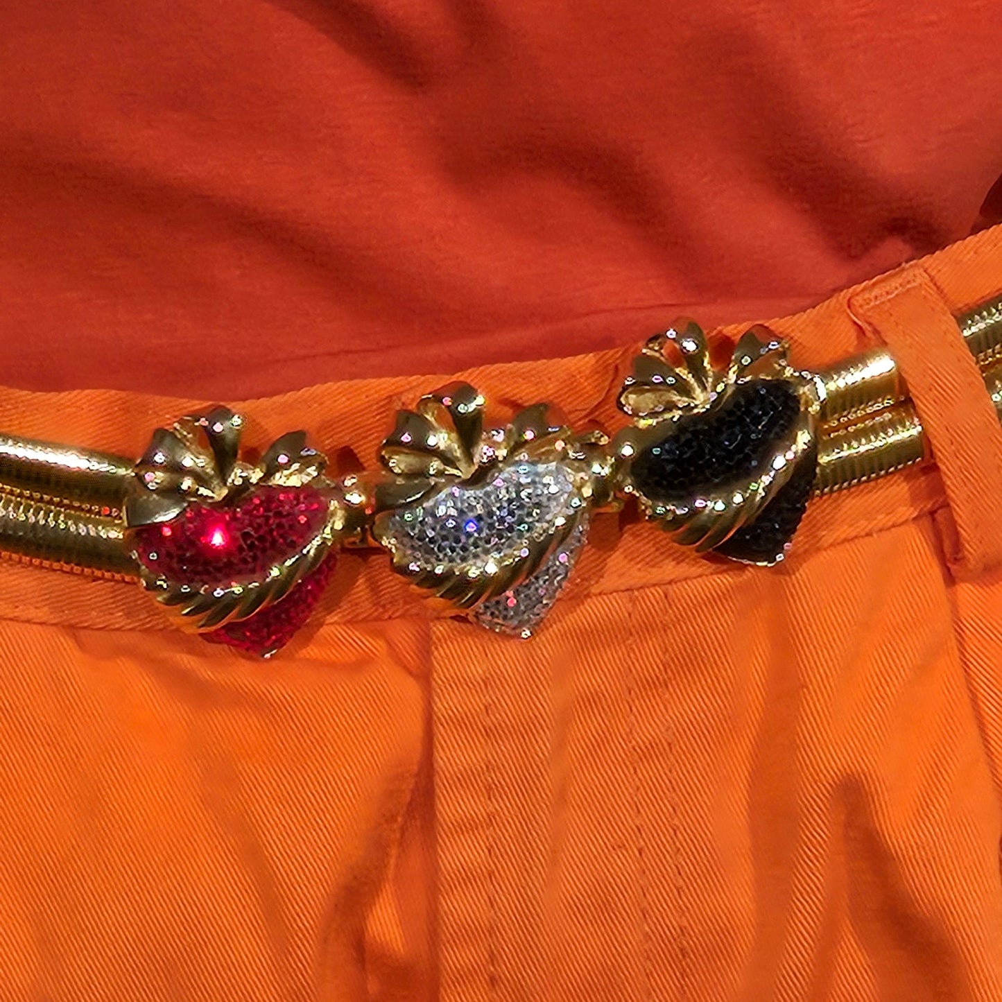 Decorative belt with charms on an orange background
