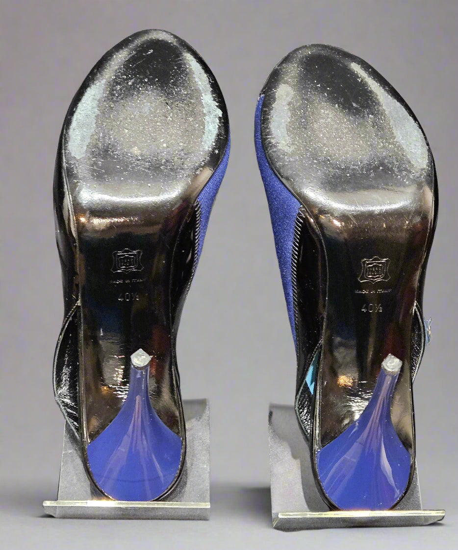Pair of high-heeled shoes with blue soles on a gray surface