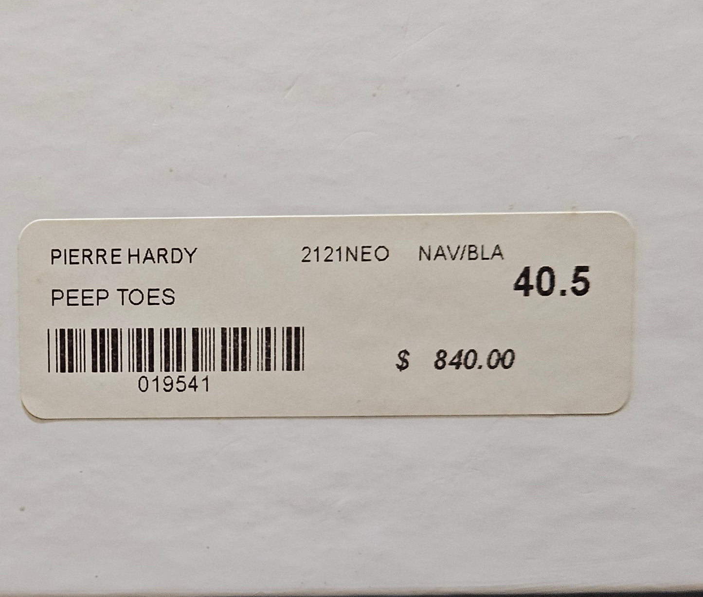 Pierre Hardy shoe box with label and price tag on a gray background
