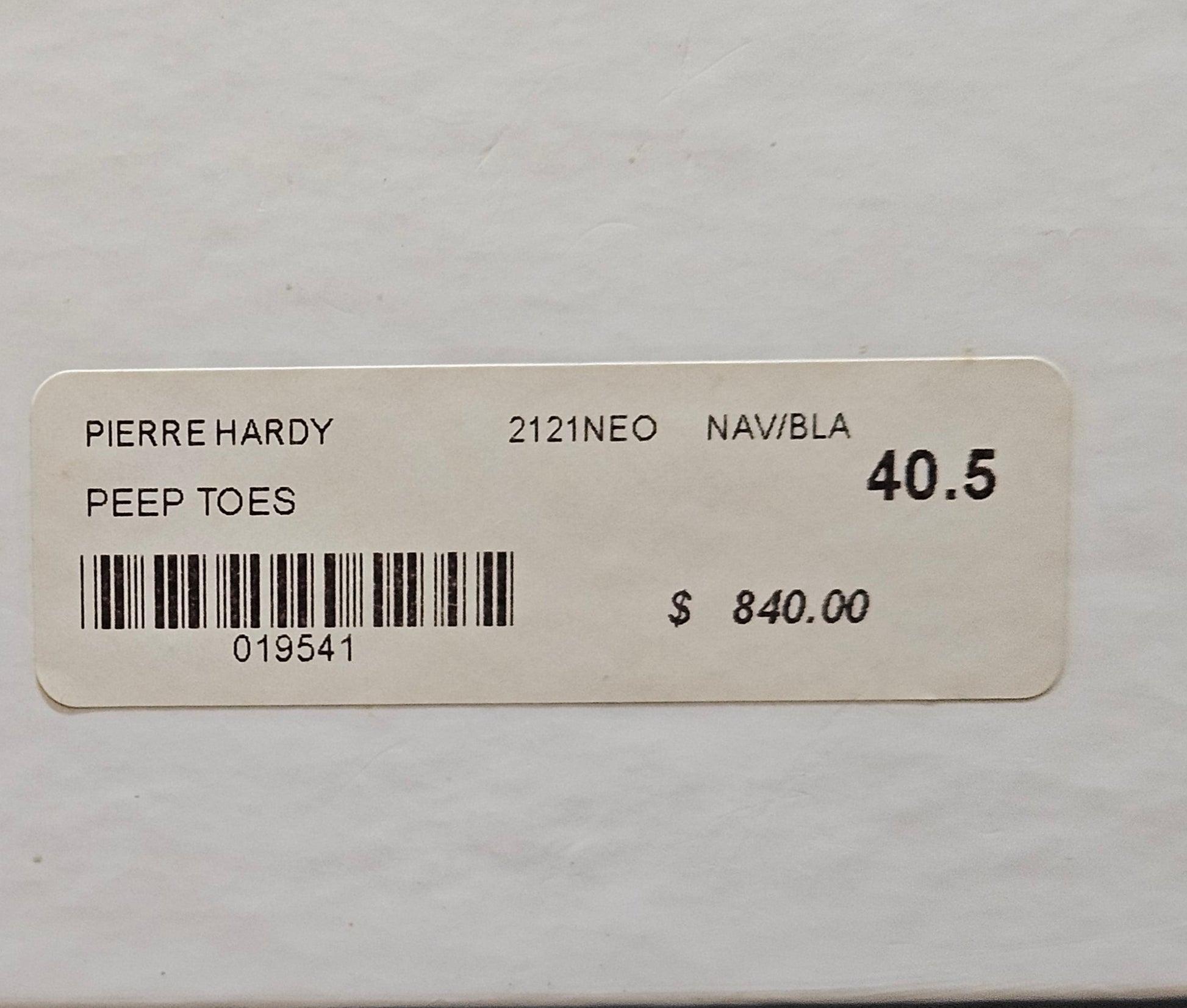 Pierre Hardy shoe box with label and price tag on a gray background