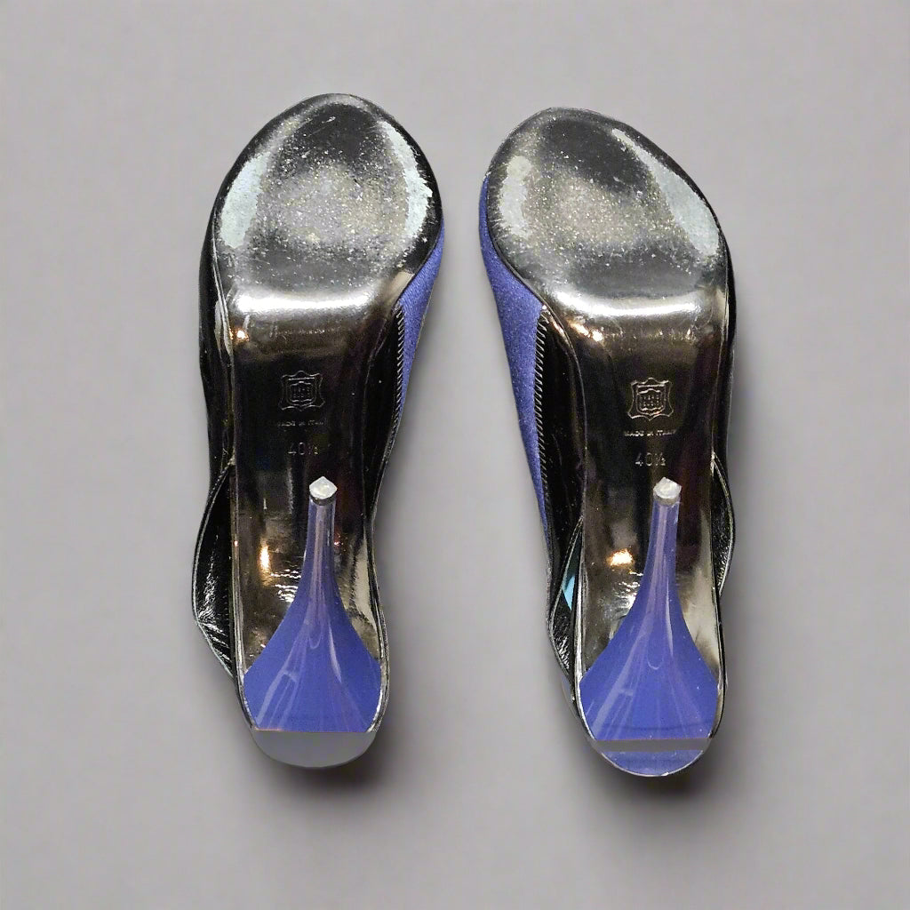 Pair of silver high-heeled shoes with blue soles on a gray fabric background
