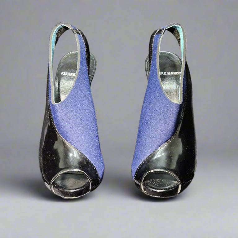 Pair of blue high-heeled shoes on clear stands against a gray background