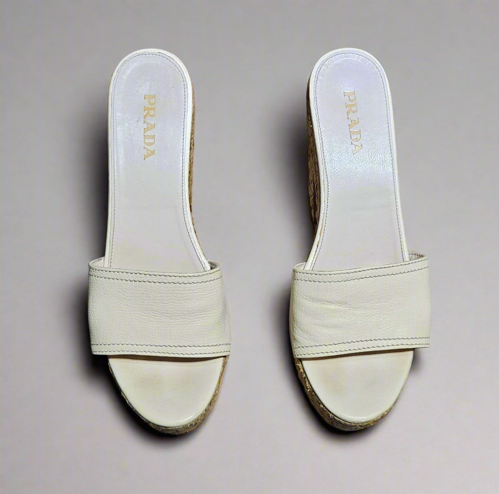 Pair of beige Prada sandals on a marble surface