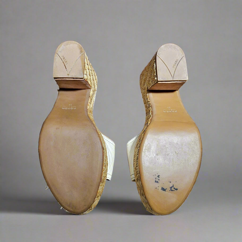 Back view of two high-heeled shoes on a marble surface with a red wall in the background.