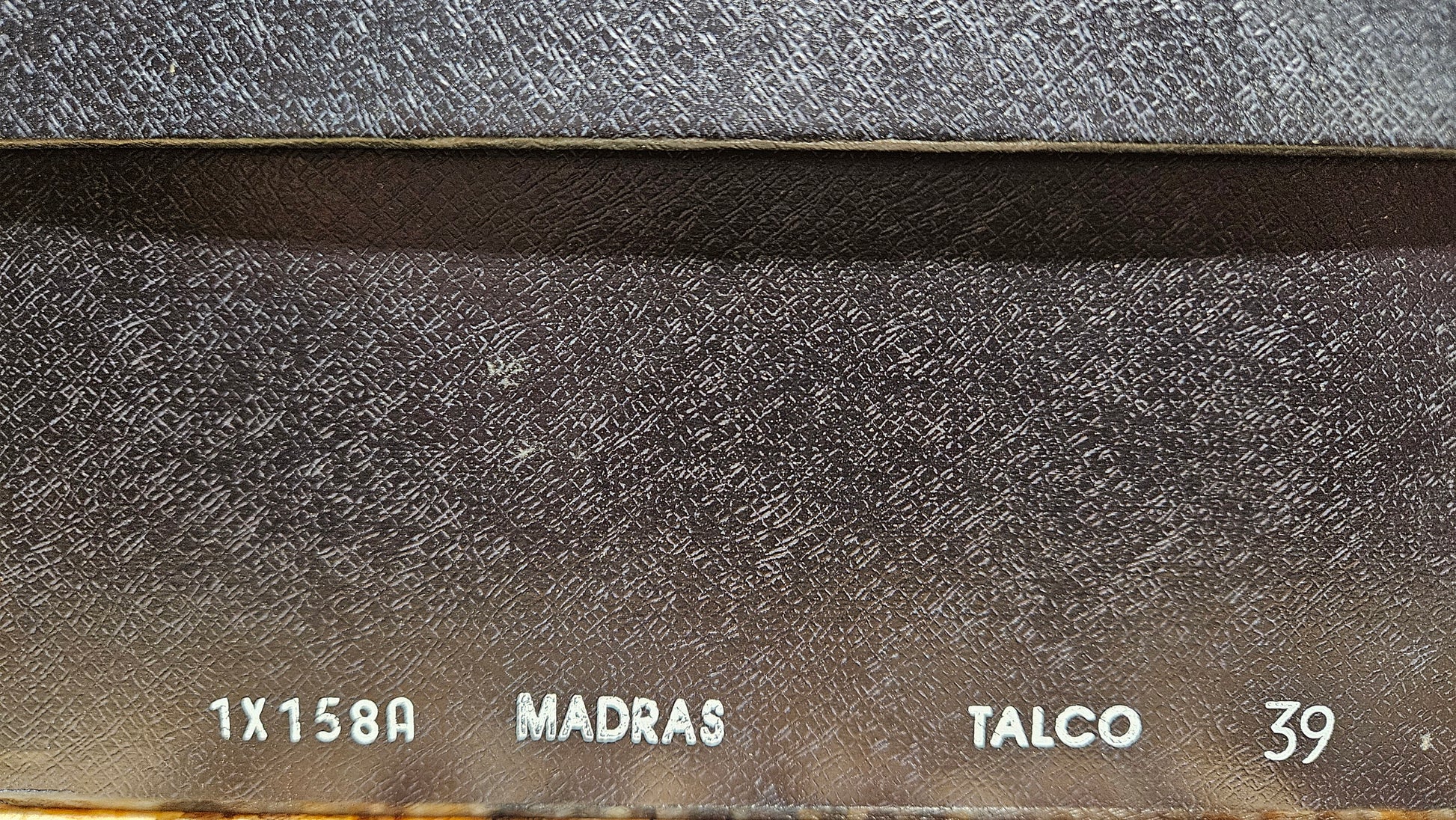 Close-up of a metal surface with text including '1X158A', 'MADRAS', 'TALCO', and '39'.