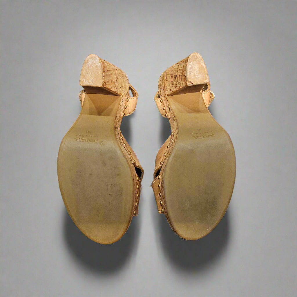Pair of gold high-heeled shoes on a gray background