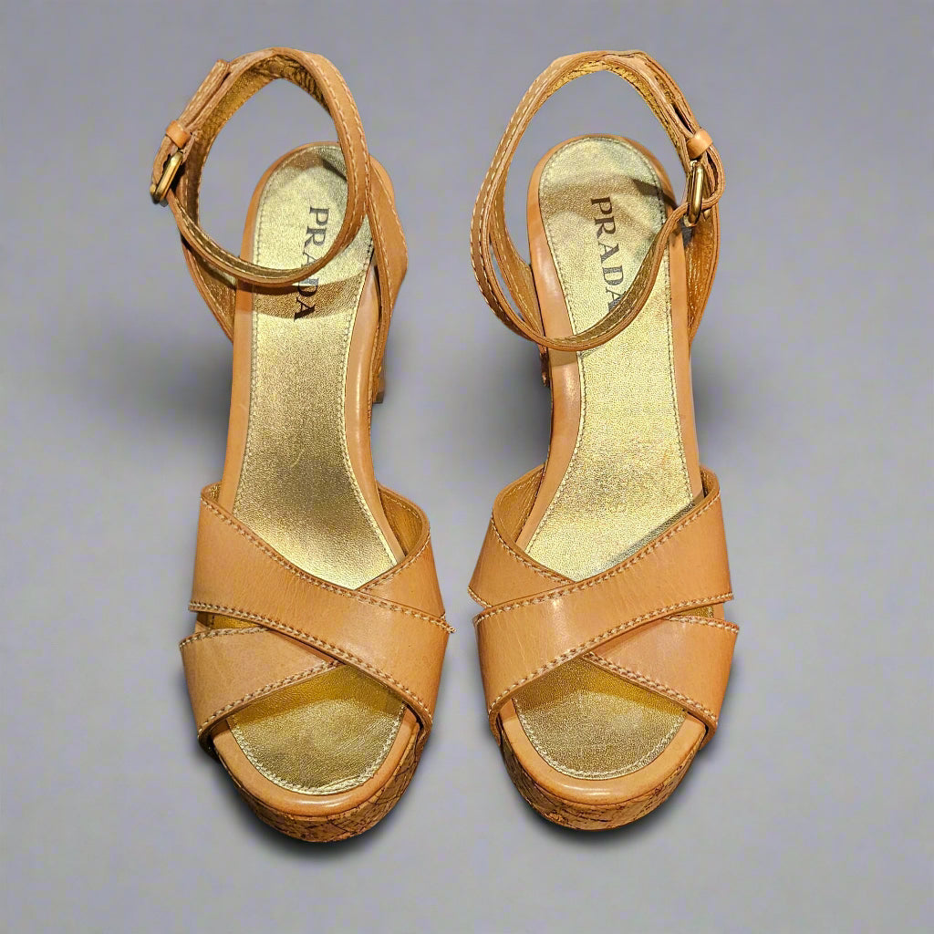 Pair of tan high-heeled sandals on a black background