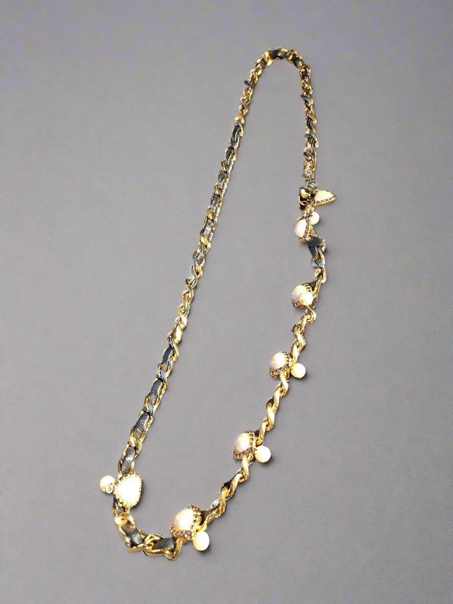 Gold chain necklace on a gray background