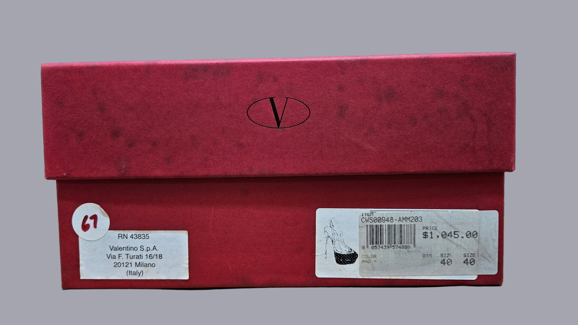 Red shoe box with a visible brand logo on a dark background
