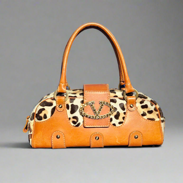 Orange handbag with leopard print pattern on a gray background