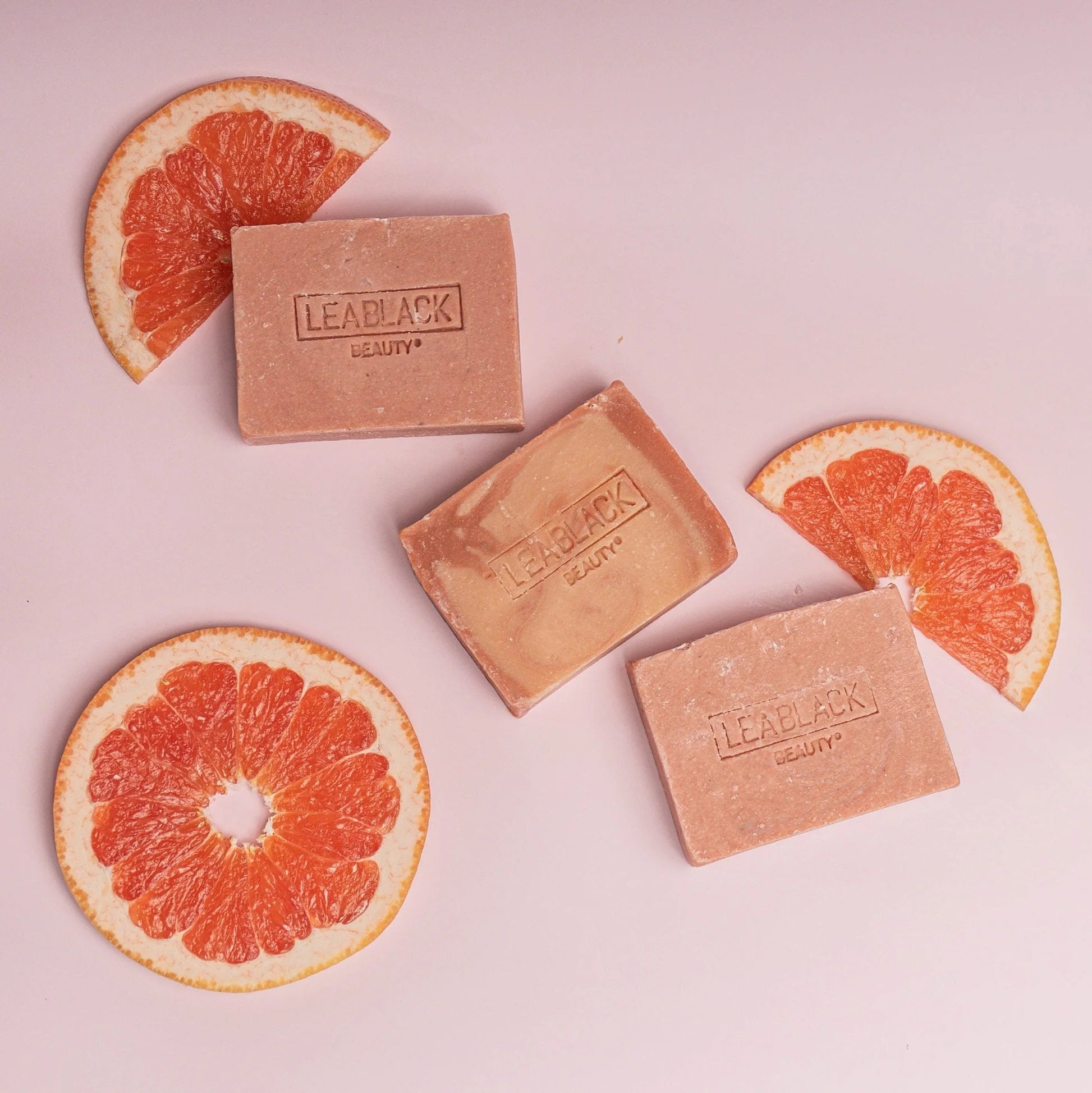pink grapefruit orange essence beauty bars next to grapefruit slices