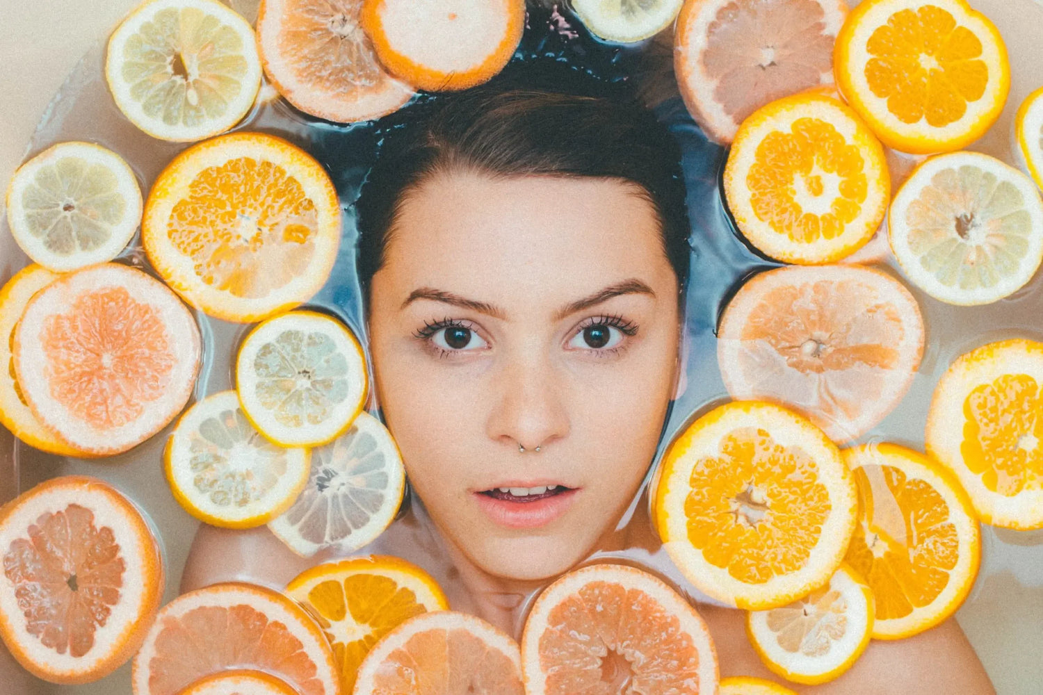 woman in water surrounded by citrus slices
