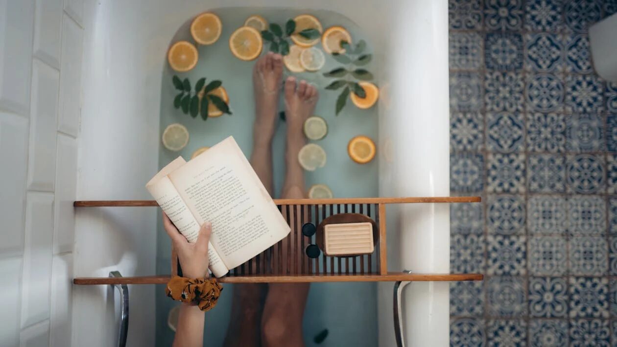 A person reading a book in a bathtub