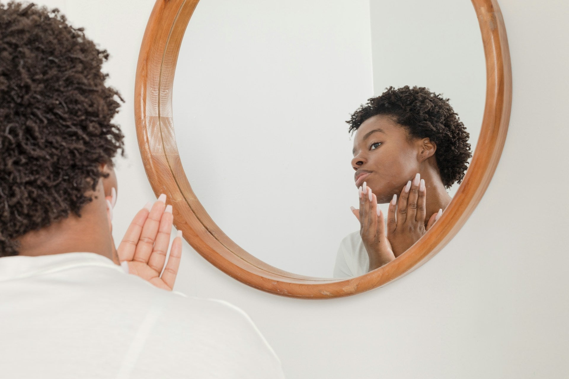 person looking in mirror at face