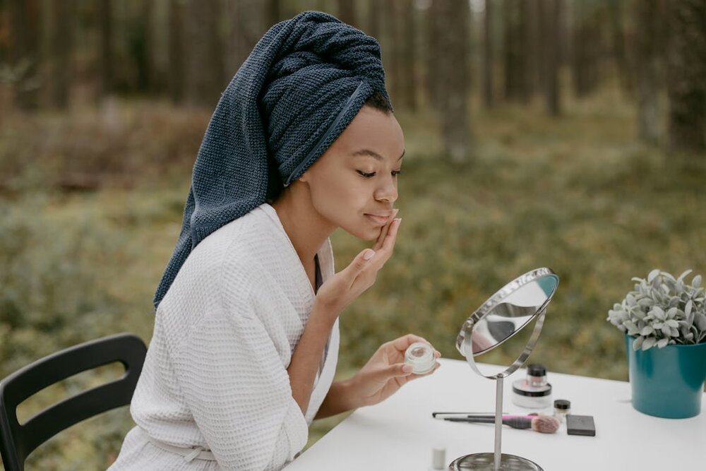 Woman applying skincare products as part of a skin flooding routine