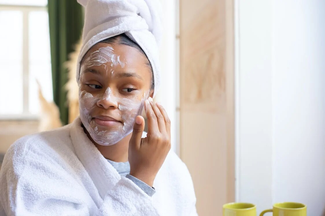 A woman applying face cream