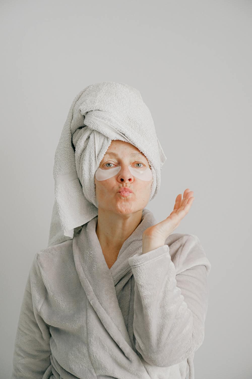 a woman in a gray robe wearing eye masks
