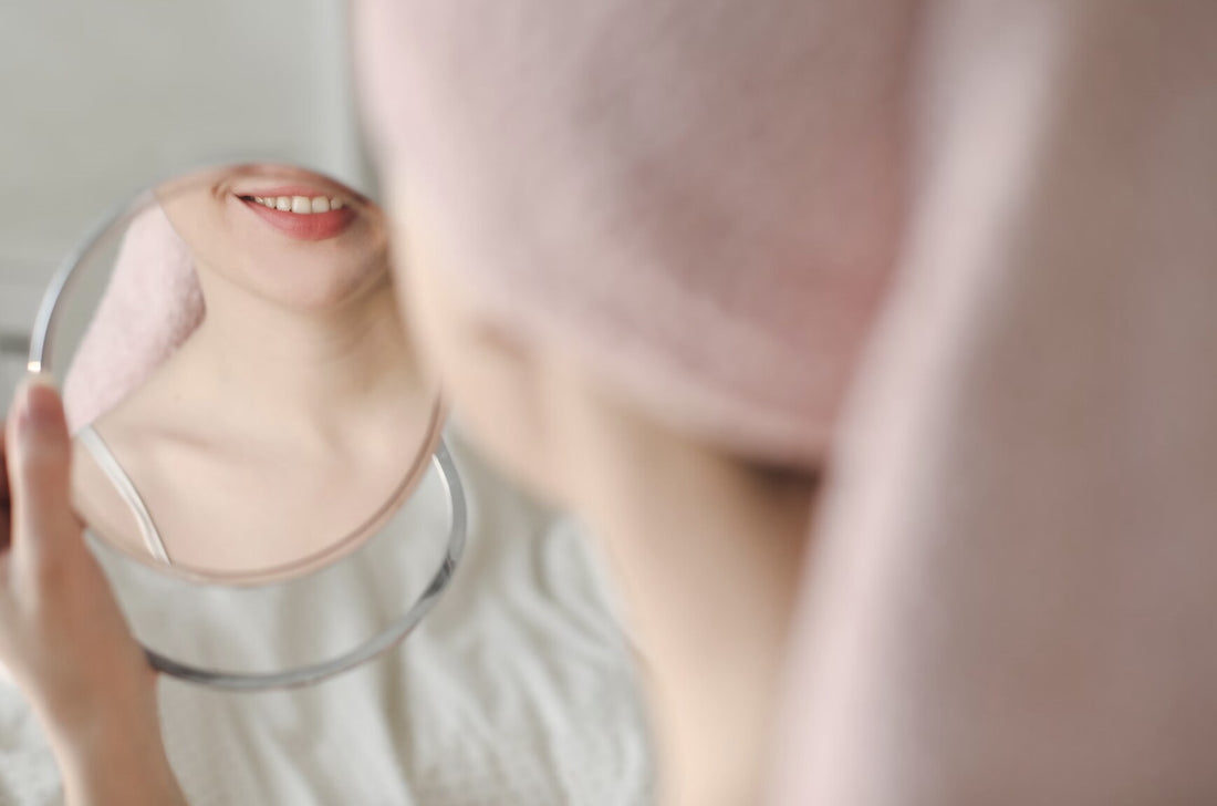woman looking in the mirror at her face