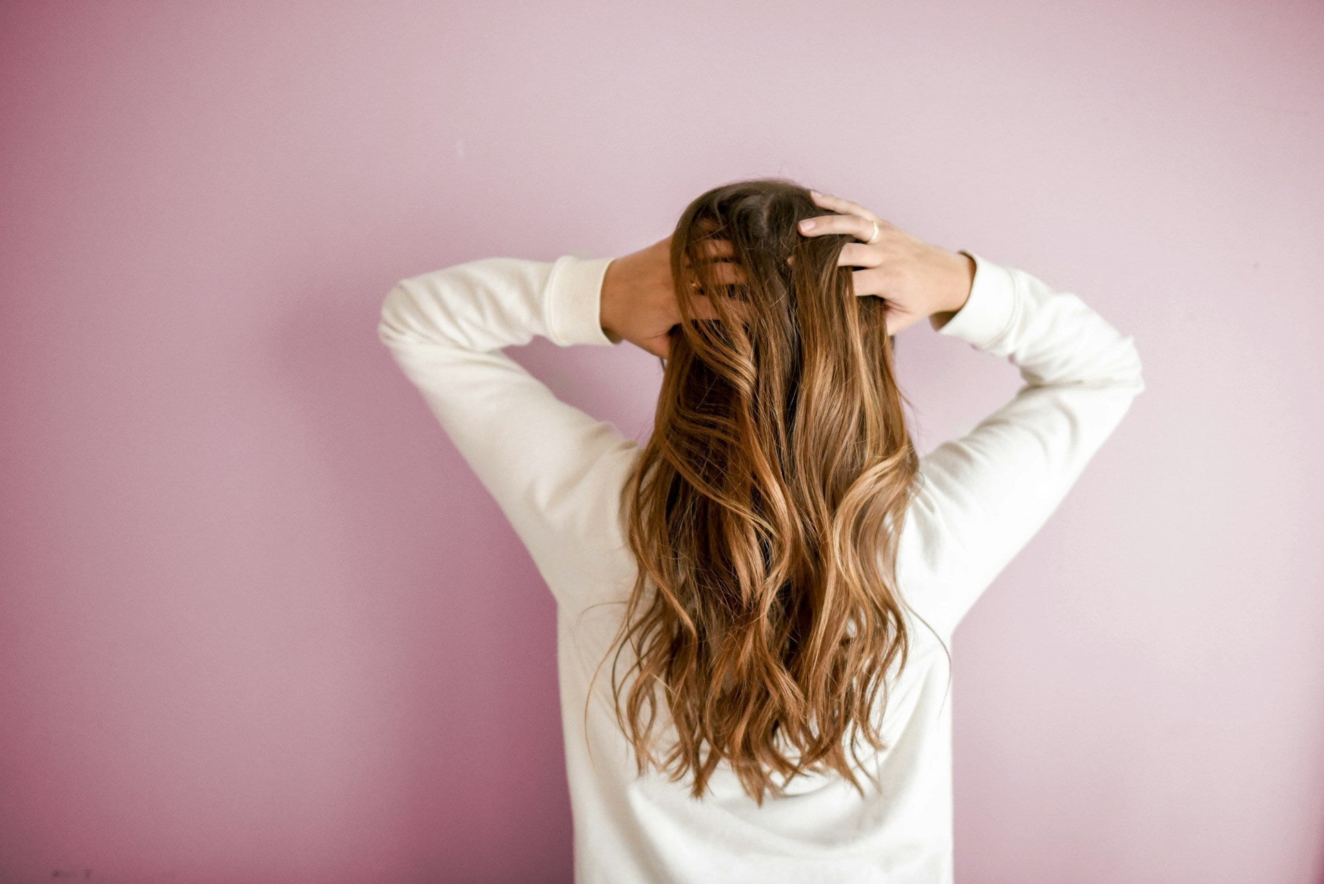 woman running her fingers through the back of her hair