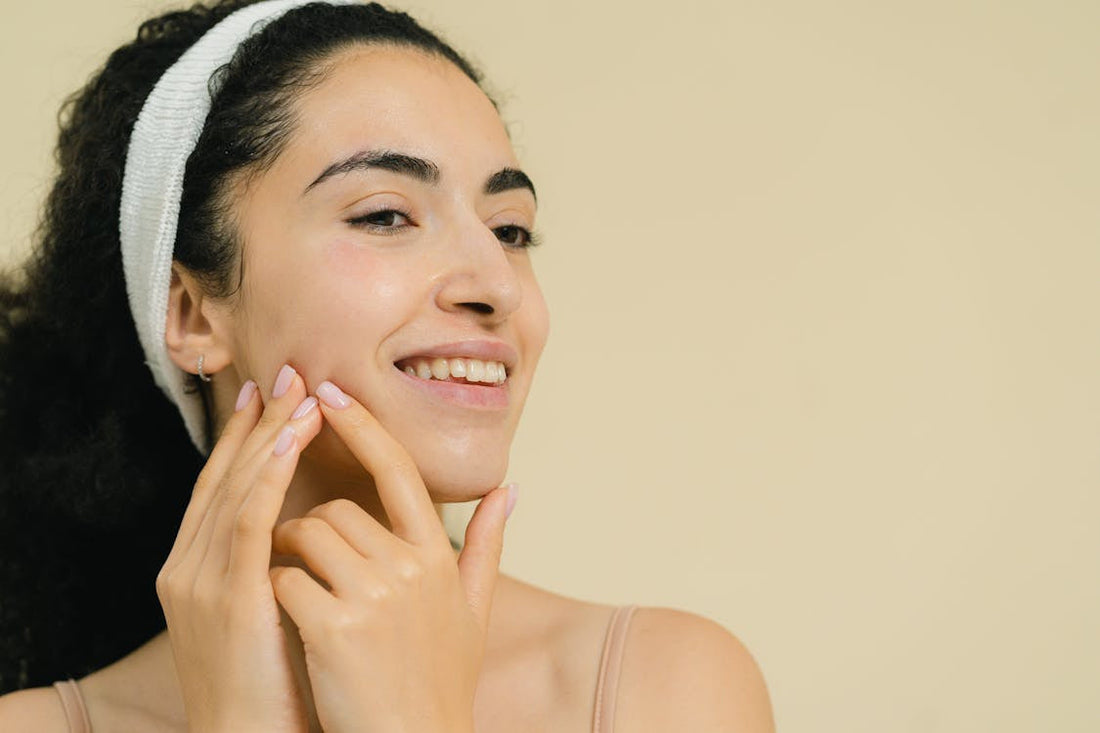 A woman touching her clear face after following the steps for how to detox your skin
