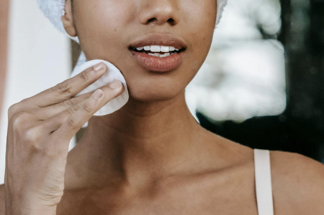 a woman with dark hair washing her face