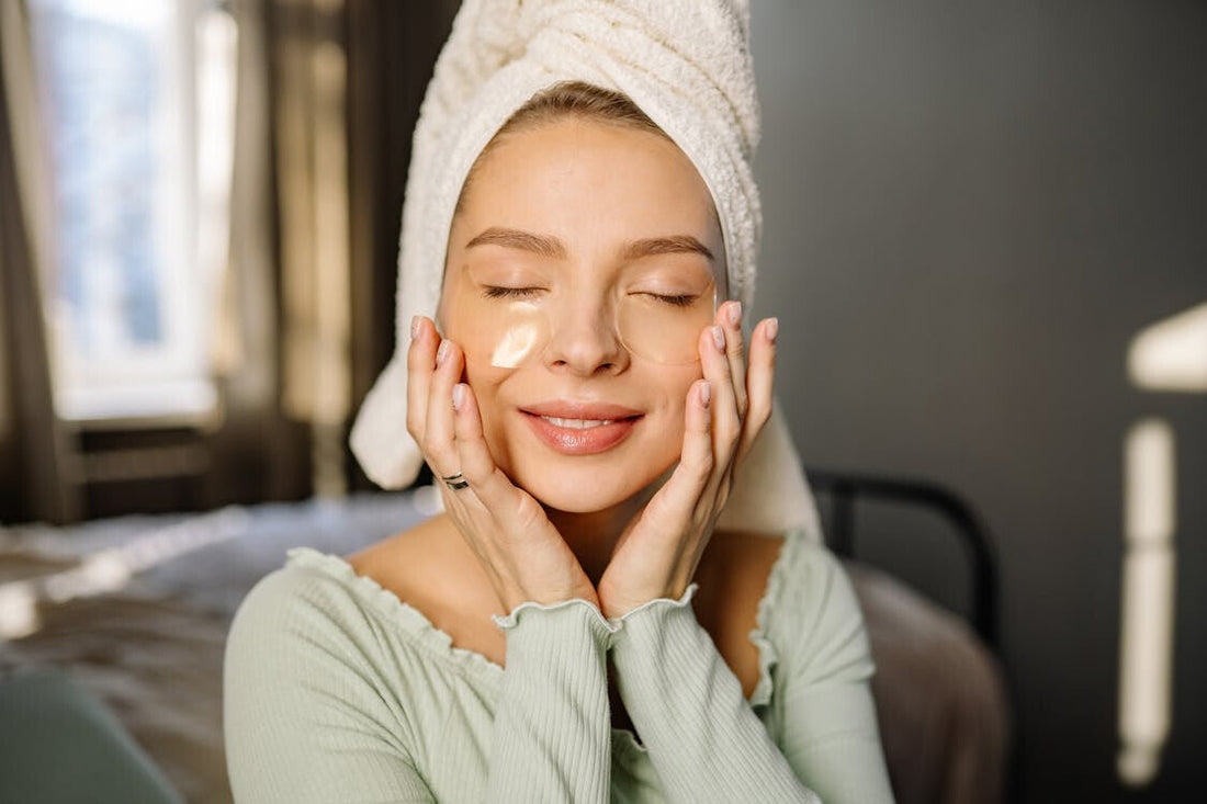 Woman with gel eye patches holding her face