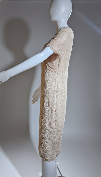Mannequin wearing a beige textured garment on a plain background