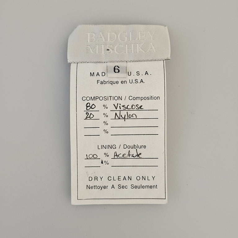 Close-up of a label on a garment with 'Badgley Mischka' branding.
