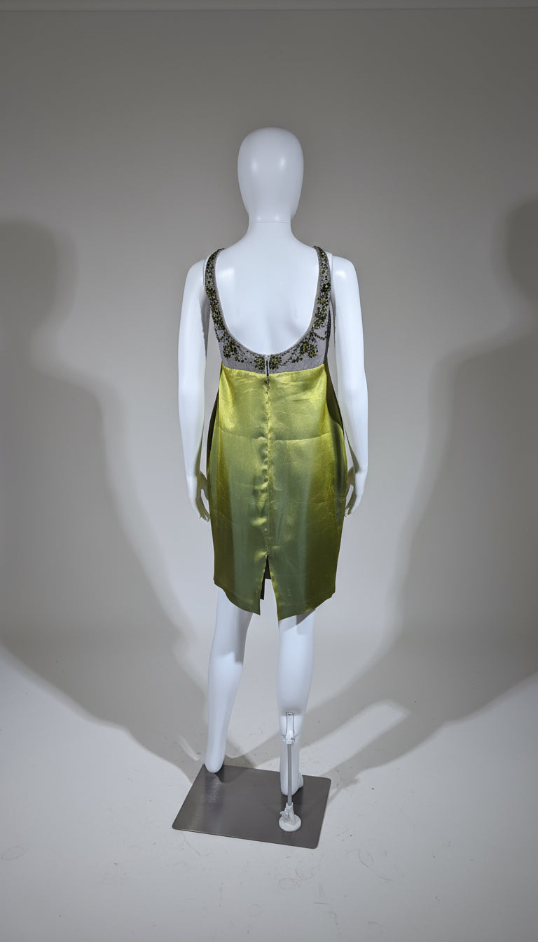 Mannequin wearing a green dress with embellishments on a gray background