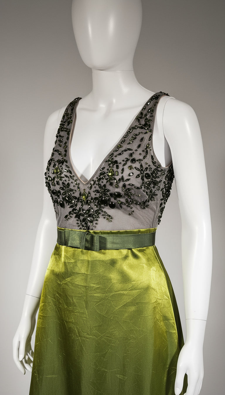 Mannequin wearing a green dress with a decorative black and gold embellished collar.