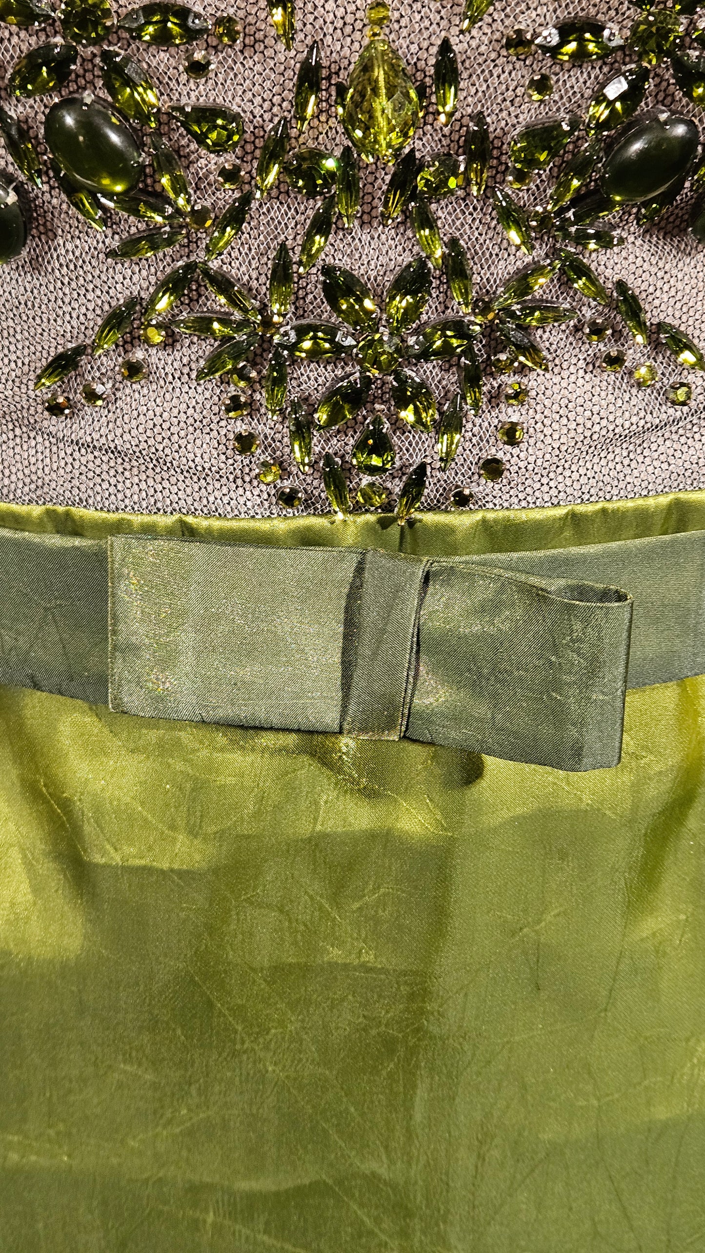 Close-up of green fabric with decorative elements on a textured background