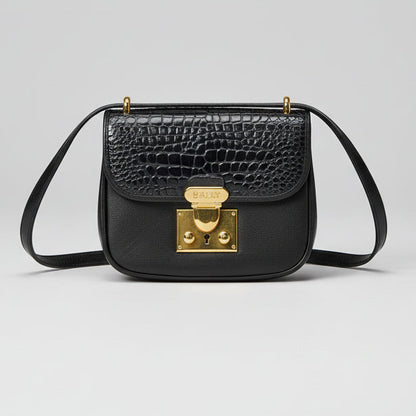 Black crocodile-patterned handbag with gold clasp on a light gray background