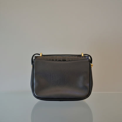 Small black leather wallet on a light gray surface