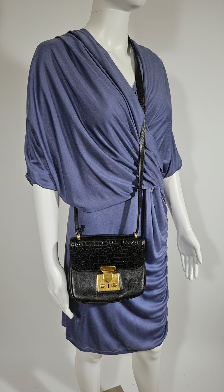 Navy blue dress with a black handbag on a mannequin against a neutral background