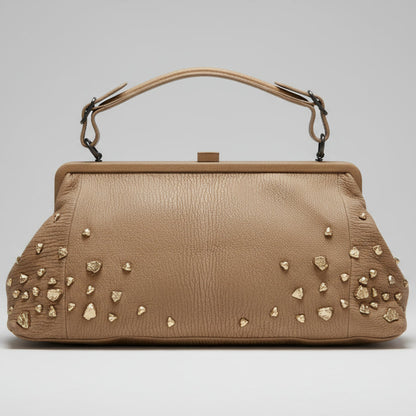 Beige handbag with decorative studs on a white background