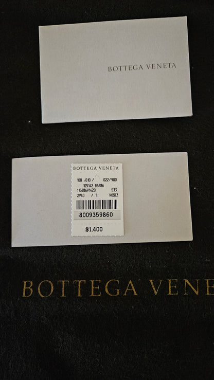 Two white labels with Bottega Veneta branding on a dark background