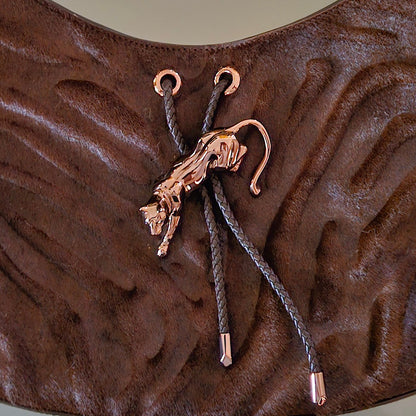 Brown textured bag with a strap and gold panther toggle