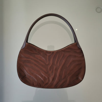 Brown textured bag on a light gray surface